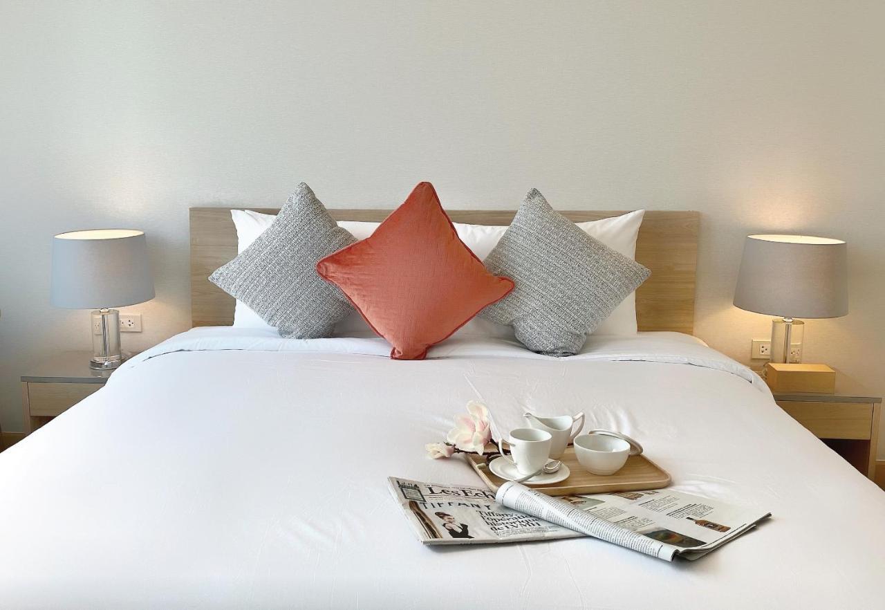 Oakwood Suites Bangkok Ngoại thất bức ảnh A bed with cushions